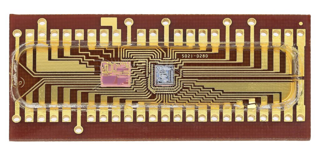 HP 1813-0091ː NMOS Hybrid Integrated Circuit - Control Logic/Assembly of precision resistors/Analog switches for the HP 3476A Digital Multimeter. Case opened to reveal the ICs dice. Manufactured by Hewlett Packard, 1970s.
